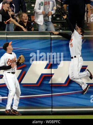 Die Baltimore Orioles David Newhan (11) springt an der Wand im ersten Inning als Jeff Fiorentino (L) Uhren Newhan einen Ball zu tiefen Feld links von den Boston Red Sox Kevin Youkilis im Baseballstadion halten und für ein Doppelzimmer am 14 September, 2006 um Orioles Park at Camden Yards, Baltimore, Maryland. (UPI Foto/Mark Goldman) Stockfoto