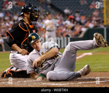 Oakland Athletics zweiter Basisspieler Mark Ellis (14) Kerben auf einem Opfer fliegen durch Mittelfeldspieler Hiram Bocachica im vierten Inning als Baltimore Orioles catcher Ramon Hernandez gilt einen späten Tag am 25. Mai 2007 An Orioles Park at Camden Yards, Baltimore. (UPI Foto/Mark Goldman) Stockfoto