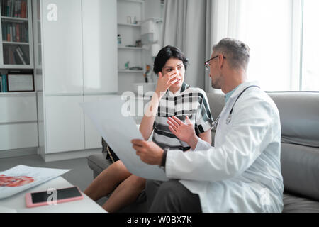 Plastischer Chirurg Brillen Beratung Kunden über Gesichtsbehandlung Korrektur Stockfoto