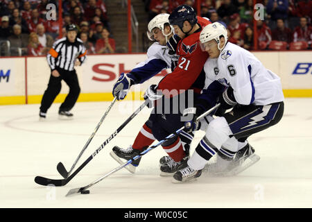 Washington Capitals center Brooks Laich (21) feuert einen Schuß gegen die Verteidigung der Tampa Bay Lightning defenseman Kurtis Foster (6) und Abwehrspieler Victor Hedman (77) im 1. Zeitraum im Verizon Center in Washington am 12. März 2010. UPI/Mark Goldman Stockfoto