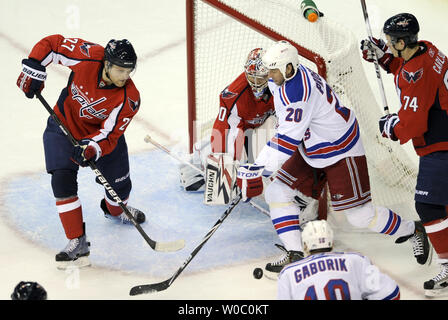 Washington Capitals defenseman Karl Alzner (27) verschiebt den Puck aus dem Torraum nach einem Schuss von New York Rangers Zentrum Vaclav Prospal(20) als Torwart Michal Neuvirth (30) folgt die Aktion im 1. Zeitraum im Verizon Center in Washington am 13. April 2011 in das erste Spiel der Playoffs. UPI/Mark Goldman Stockfoto