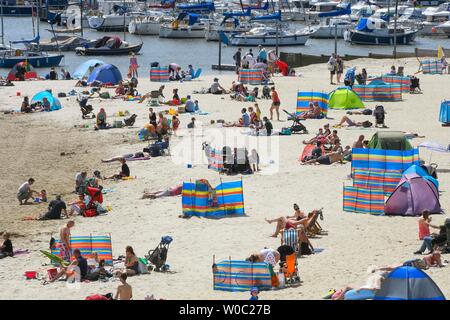 Lyme Regis, Dorset, Großbritannien. 27. Juni 2019. UK Wetter. Sonnenanbeter in Scharen zu den Strand im Badeort von Lyme Regis in Dorset ein Tag der klaren blauen Himmel zu genießen und die sengende Sonne. Foto: Graham Jagd-/Alamy leben Nachrichten Stockfoto