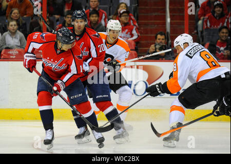 Washington Capitals linken Flügel Martin Erat (10) und rechten Flügel Troy Brouwer (20) versuchen, den Puck gegen die Philadelphia Flyers Verteidiger Nicklas Grossmann (8) in der ersten Periode im Verizon Center in Washington, D.C. die Kontrolle am 2. März 2014. UPI/Mark Goldman Stockfoto