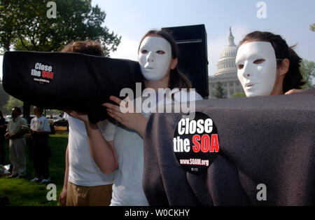 Zwei Demonstranten halten Särge bei einer Rallye für die Schließung der Schule der Amerikas, jetzt genannt der westlichen Hemisphäre Institut für die Zusammenarbeit in Sicherheitsfragen, in Washington am 24. April 2006. Das Institut ist ein kampftraining Schule für lateinamerikanische Soldaten in Fort Benning, Georgia. Nach der Schule der Americas Watch, die die Rallye gefördert, die Schule lehrt, Folter, Mord und psychologische Kriegsführung Techniken. (UPI Foto/Kevin Dietsch) Stockfoto