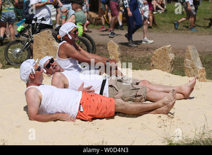 Festivalbesucher ein Sonnenbad im grünen Bereich des Glastonbury Festival würdig Farm, Pilton, Somerset. Stockfoto