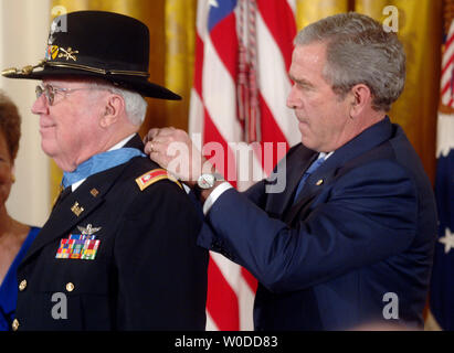 Präsident George W. Bush die Vergabe der Ehrenmedaille der pensionierte Armee Oberstleutnant Bruce Crandall, während einer Zeremonie im East Room des Weißen Hauses in Washington am 26. Februar 2007. Crandall erhielt die Medaille für seinen heldenhaften Aktionen in Vietnam, nach der freiwillig Fliegen sein Hubschrauber in feindliche Feuer verwundete Soldaten zu retten. (UPI Foto/Kevin Dietsch) Stockfoto