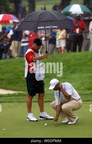 Tiger Woods' caddie Steve Williams halten einen Regenschirm über Holz als er einen Schlag auf dem 2. Grün während des ersten Umlauf der AT&T National am Congressional Country Club in Potomac, Maryland am 5. Juli 2007. (UPI Foto/Kevin Dietsch) Stockfoto