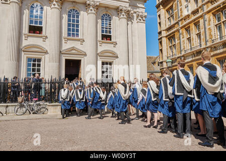 Feier an der Universität Cambridge, England, als Diplomanden Studenten (von Gonville and Caius College) in Ihren akademischen Kittel Prozess in eine geordnete Warteschlange Senat Haus am 27. Juni 2019 für Ihre Abschlussfeier. Stockfoto