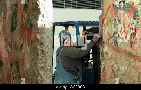 Arbeitnehmer Position Teile der Berliner Mauer an der Newseum, der sich derzeit im Bau auf Oktober 30, 2007, in Washington. Acht Teile der Mauer und Wachturm zu sehen sein, wenn das Museum fertig ist. (UPI Foto/Roger L. Wollenberg) Stockfoto