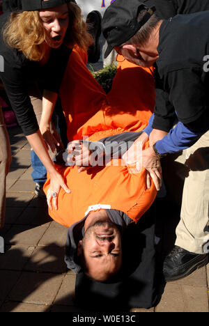 Maboud Ebrahimzadeh (C) beteiligt sich mit anderen anti-Aktivisten in einem waterboarding Demonstration vor der US-Justizministerium in Washington Folter am 5. November 2007. Zadeh, der andere Aktivist gab eine live Demonstration der vermeintlichen US-Integration wie das so genannte waterboarding, in der die Person zu simulierten Ertrinkens ausgesetzt ist, Präsident Bushs Ernennung der Richter Michael Mukasey US Attorney General zu protestieren. (UPI Foto/Kevin Dietsch) Stockfoto