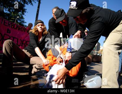 Maboud Ebrahimzadeh (C) beteiligt sich mit anderen anti-Aktivisten in einem waterboarding Demonstration vor der US-Justizministerium in Washington Folter am 5. November 2007. Zadeh, der andere Aktivist gab eine live Demonstration der vermeintlichen US-Integration wie das so genannte waterboarding, in der die Person zu simulierten Ertrinkens ausgesetzt ist, Präsident Bushs Ernennung der Richter Michael Mukasey US Attorney General zu protestieren. (UPI Foto/Kevin Dietsch) Stockfoto