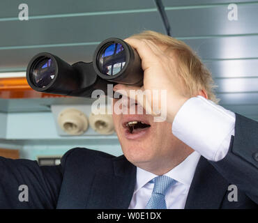 Konservativen Spitzenkandidaten Boris Johnson auf der Brücke der Isle of Wight Fähre wie Segel setzt aus Portsmouth. Stockfoto