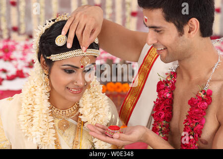 Indische paar Durchführung Sindoor Daan Zeremonie in malayalee Hochzeit Stockfoto