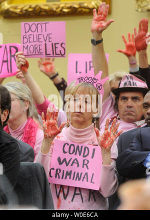 Anti-kriegs-Demonstranten aus Code rosa bis rot lackiert Hände und Zeichen, während Außenministerin Condoleezza Rice bezeugt vor einem Haus, ausländische Geschäftsbetriebe und verwandter Programme Unterausschuss für die ausländische und internationale Angelegenheiten Haushalt Capitol Hill in Washington am 12. März 2008. (UPI Foto/Kevin Dietsch) Stockfoto