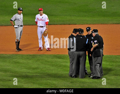 New York Yankees dritter Basisspieler Alex Rodriguez (L) und Philadelphia Phillies Second Baseman Chase Utley ansehen, da die Schiedsrichter auf dem Feld im vierten Inning von Spiel 3 der World Series treffen in Philadelphia am 31. Oktober 2009. Die Schiedsrichter waren Sitzung ein homerun geschlagen durch New York Yankees dritter Basisspieler Alex Rodriguez zu diskutieren. UPI/Kevin Dietsch Stockfoto
