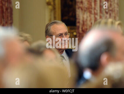 Der ehemalige Verteidigungsminister Donald Rumsfeld sieht auf wie der ehemalige Außenminister Colin Powell spricht vor Powells offizielle Portrait an das State Department in Washington am 7. Dezember 2009 vorgestellt wurde. UPI/Roger L. Wollenberg Stockfoto