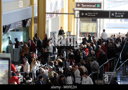 Passagiere warten in einer Linie an Ronald Reagan National Airport, in der Nähe von Washington, in Arlington, Virginia, am 29. Dezember 2009. Die Kapitäne an Bord US-Flüge haben jetzt nach eigenem Ermessen, ob die Sicherheitsverfahren Fluggästen untersagt ist, nach dem Umzug um die Kabine auf gewerblichen Flügen während der letzten Stunde des Fluges durchzusetzen. TSA hat auch Screening Verfahren auf Flughäfen nach dem vereitelten Terroranschlag auf Northwest Airlines Flug 253 nach Detroit am 25. Dezember trat. UPI/Alexis C Glenn Stockfoto