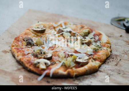 Rustikale Pizza auf Holz- Schiefer Stockfoto