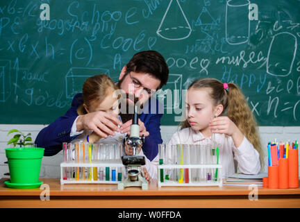 Erklärt Biologie für Kinder. Wie Interesse Kinder studieren. Faszinierende Biologie Lektion. Man bärtige Lehrer arbeiten mit Mikroskop und Reagenzgläser in Biologie Klassenzimmer. Schule Lehrer der Biologie. Stockfoto