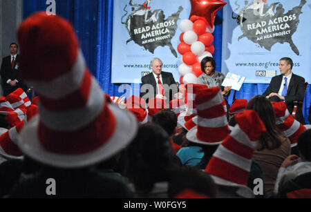 First Lady Michelle Obama liest "die Katze im Hut" Grundschüler aus Arlington, Virginia und den Bezirk Columbia auf der 106. Geburtstag von Autor Dr. Suess an der Bibliothek des Kongresses in Washington am 2. März 2010. Die First Lady wurde von Bildungsminister Arne Duncan (R) und National Education Association Präsident Dennis Van Roekel (L). UPI/Alexis C Glenn Stockfoto