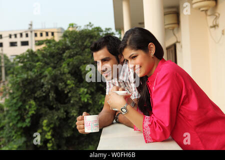 Paar ein Geländer gelehnt und Kaffee trinken Stockfoto