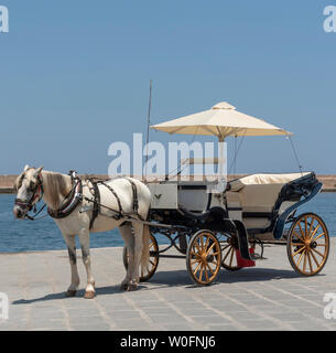 Chania, Kreta, Griechenland, Juni 2019. Kutsche auf dem alten Venetion Hafen in Chania wartenden Fahrgäste auf einer Fahrt zu nehmen. Stockfoto