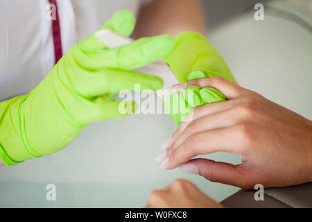 Maniküre. Geschickte Master der Maniküre holding Datei in Ihre Hände bei der Arbeit in ihrem Schönheitssalon Stockfoto