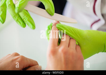 Maniküre. Geschickte Master der Maniküre holding Datei in Ihre Hände bei der Arbeit in ihrem Schönheitssalon Stockfoto