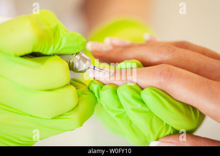 Maniküre. Geschickte Master der Maniküre holding Datei in Ihre Hände bei der Arbeit in ihrem Schönheitssalon Stockfoto