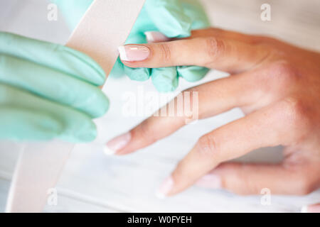 Maniküre. Geschickte Master der Maniküre holding Datei in Ihre Hände bei der Arbeit in ihrem Schönheitssalon Stockfoto