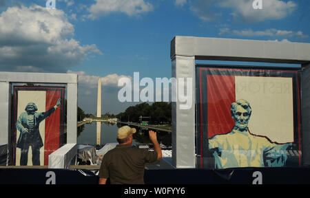 Ein Mann nimmt Fotos zwischen Poster von Frederick Douglass (L) und Präsident Abraham Lincoln, in der Nähe des Lincoln Memorial und dem Washington Monument in Washington am 27. August 2010. Viele Konservative haben abgesteckt Positionen in der Nähe der Gedenkstätte für das Morgige "Wiederherstellung der Ehre" konservative politische Kundgebung, organisiert von Fox News TV host Glenn Beck. Viele von Amerikas top Konservativen wird auf der Kundgebung, darunter auch der ehemalige Republikanische Präsidentschaftskandidat Sarah Palin sprechen. UPI/Alexis C Glenn Stockfoto