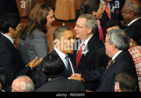 Us-Präsident Barack Obama wird durch Mitglieder des Kongresses begrüßt, als er das Haus Kammer seine Rede zur Lage der Union zu einer gemeinsamen Sitzung der Kongress im Kapitol in Washington am 25. Januar 2011 zu liefern. Hinter Obama Republikanische Senat Minderheit Führer Mitch McConnell aus Kentucky. Obama konzentrierte sich auf die Wirtschaft und insbesondere die Schaffung von Arbeitsplätzen. UPI/Pat Benic Stockfoto