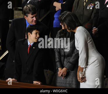 First Lady Michelle Obama grüßt Roxanna und John Green, Eltern von Christina Grün, und Sohn Dallas, bevor US-Präsident Barack Obama seine Rede zur Lage der Union zu einer gemeinsamen Sitzung des Kongresses im Haus Kammer des US-Kapitol in Washington am 25. Januar 2011. Ihre Tochter, die späten Christina Taylor, 9 Jahre alt, wurde getötet, als ein bewaffneter Bandit schuss Kongressabgeordneten Gabrielle Giffords in Tucson Anfang dieses Monats. UPI/Roger L. Wollenberg Stockfoto