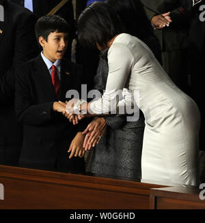 First Lady Michelle Obama grüßt Dallas Green, Alter 11, bevor US-Präsident Barack Obama seine Rede zur Lage der Union zu einer gemeinsamen Sitzung des Kongresses im Haus Kammer des US-Kapitol in Washington am 25. Januar 2011. Seine Schwester, der späte Christina Taylor, 9 Jahre alt, wurde getötet, als ein bewaffneter Bandit schuss Kongressabgeordneten Gabrielle Giffords in Tucson Anfang dieses Monats. UPI/Roger L. Wollenberg Stockfoto