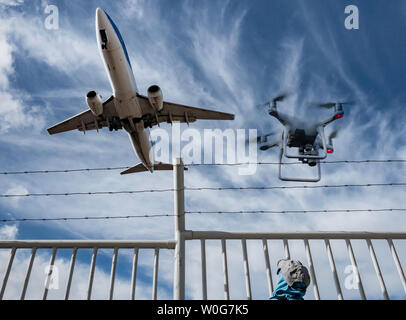 Frau, die Flugzeuge/Flugzeuge von hinter Stacheldraht-Perimeter, Grenzzaun beobachtet. Konzeptbild: Russland Ukraine-Konflikt, keine Flugzone, Flüchtlingskrise. Stockfoto