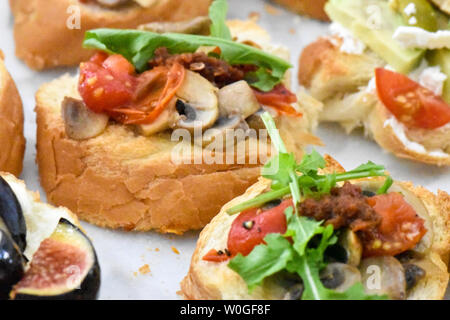 Sauber, gesund naschen Avocado, Tomate, Pilz und Feigen bereit, mit Kräuter, Blätter und ein kleines Stück Baguette serviert werden. Ideal bite Stockfoto