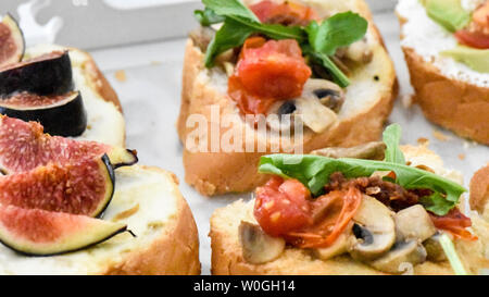 Sauber, gesund naschen Avocado, Tomate, Pilz und Feigen bereit, mit Kräuter, Blätter und ein kleines Stück Baguette serviert werden. Ideal bite Stockfoto