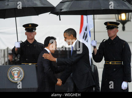 Us-Präsident Barack Obama (R) schüttelt Hände mit südkoreanischen Präsidenten Lee Myung-bak, wie er begrüßt ihn im Regen an das Weiße Haus auf der South Lawn in Washington, DC am 13. Oktober 2011. Der Staatsbesuch kommt nur einen Tag nach dem Kongress ein Freihandelsabkommen mit Südkorea verabschiedet. UPI/Pat Benic Stockfoto