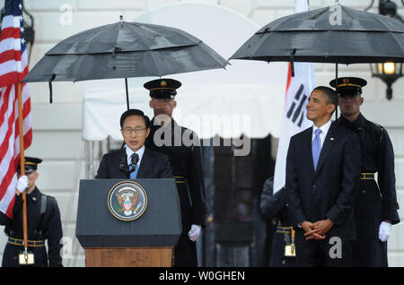 Us-Präsident Barack Obama lächelt, als er zum südkoreanischen Präsidenten Lee Myung-bak hört während der Begrüßungszeremonie im Regen im Weißen Haus auf der South Lawn in Washington, DC am 13. Oktober 2011. Der Staatsbesuch kommt nur einen Tag nach dem Kongress ein Freihandelsabkommen mit Südkorea verabschiedet. UPI/Pat Benic Stockfoto