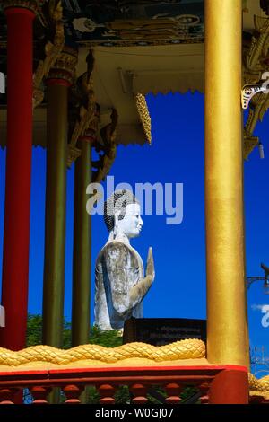 Blick auf goldenen Säulen, Trommel und weißen Buddha Statue gegen den blauen Himmel in buddhistischen Tempel - Wat Ek Phnom, in der Nähe von Battambang, Kambodscha Stockfoto