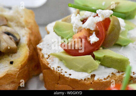 Sauber, gesund naschen Avocado, Tomate, Pilz und Feigen bereit, mit Kräuter, Blätter und ein kleines Stück Baguette serviert werden. Ideal bite Stockfoto