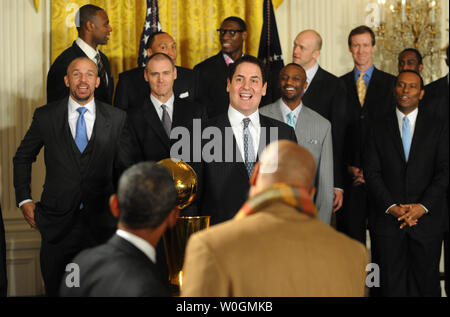 Us-Präsident Barack Obama teilt ein Lachen mit Dallas Mavericks Besitzer Mark Cuban (C) wie Obama begrüßt die Gäste während einer Zeremonie zu Ehren des 2011 NBA Champions im East Room des Weißen Hauses am 9. Januar 2012 in Washington, DC. Obama teilte einige lacht, als er Dallas für ihre ersten Nationalen Basketball Liga Meisterschaft gratuliert. UPI/Pat Benic Stockfoto