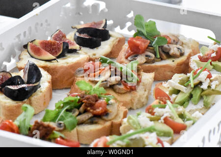 Sauber, gesund naschen Avocado, Tomate, Pilz und Feigen bereit, mit Kräuter, Blätter und ein kleines Stück Baguette serviert werden. Ideal bite Stockfoto