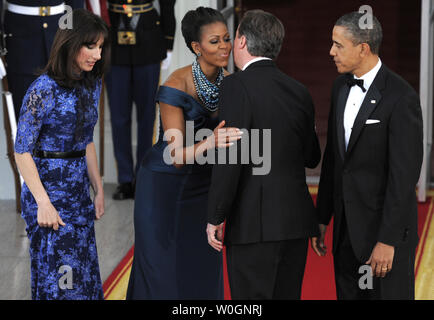 US-Präsident Barack Obama (R) Uhren als First Lady Michelle Obama (2., L) umfasst der britische Premierminister David Cameron und er und seine Frau Samantha kommen an das Weiße Haus Norden Portico für ein Abendessen, März 14, 2012, in Washington, DC. Das Abendessen endet ein Tag der bilateralen Treffen auf die Situation in Afghanistan, wie mit Irans Problem befassen, humanitären Bemühungen in Syrien, und wirtschaftliche Fragen im Vorfeld dieser Federn G-8-Treffen in den USA. UPI/Mike Theiler Stockfoto