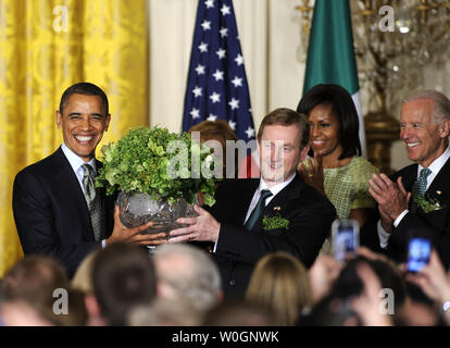 US-Präsident Barack Obama (L) nimmt eine Schüssel shamrocks vom irischen Premierminister Enda Kenny als First Lady Michelle Obama (2., R) und Vizepräsident Joe Biden (R) bei einem Empfang im East Room des Weißen Hauses, März 20, 2012, in Washington, DC. Die beiden Führer einen Arbeitstag zu Diskussionen über wirtschaftliche Angelegenheiten gewidmet, die Irland Frieden halten Beteiligungen und aussenpolitischen Themen wie Syrien und Iran. UPI/Mike Theiler Stockfoto