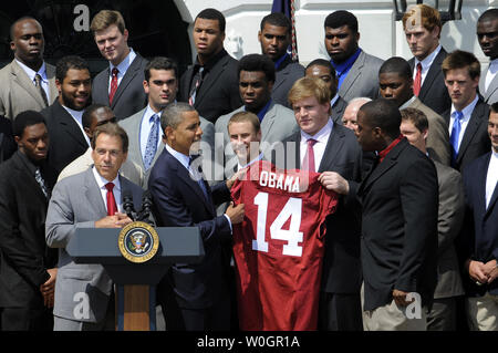 US-Präsident Barack Obama übernimmt ein Jersey von Alabama Crimson Tide Spieler Barrett Jones (Jersey) und Damion Square (R) als Head Coach Nick Saban macht Erläuterungen (L) auf dem Südrasen des Weißen Hauses, April 19, 2012, in Washington, DC. Die Zahl *14* in Alabama insgesamt nationale Meisterschaften bedeutet, nachdem Sie LSU, 21-0, im Januar besiegt, für die BCS-College Football Championship. UPI/Mike Theiler Stockfoto