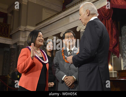 Neu gewählten Sen. Mazie Hirono (D-HI), (L) steht neben ihrem Ehemann Leighton Kim Oshima, als sie an einer Re-enactment ihrer Vereidigung von Vizepräsident Joe Biden (R), Im alten Plenarsaal des Senats an das US Capitol, Januar 3, 2013, in Washington, DC. Der Senator war zuvor offiziell in der auf dem Boden des Senats vereidigt Die 113. Kongress zu beginnen. UPI/Mike Theiler Stockfoto