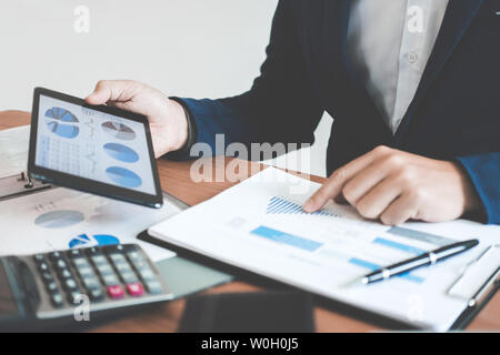 Geschäftsmann mit Text Informationen zum digitalen Tablet finanzielle statistische Daten zu analysieren und die Kosten des Investitionsvorhabens berechnen. Stockfoto