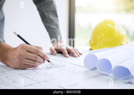 Construction Engineering oder Architekt Hände arbeiten an blueprint Inspektion am Arbeitsplatz, beim Prüfen von Informationen zeichnen und skizzieren für arachiten Stockfoto