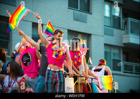 NEW YORK CITY - 25 Juni, 2017: Teilnehmer wave Regenbogenfahnen auf einen Schwimmer in der jährlichen Pride Parade durch Greenwich Village. Stockfoto